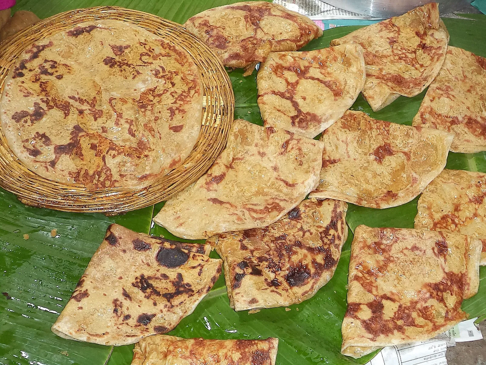Holige, the Karnataka name for the sweet dal flatbread, folded on a banana leaf