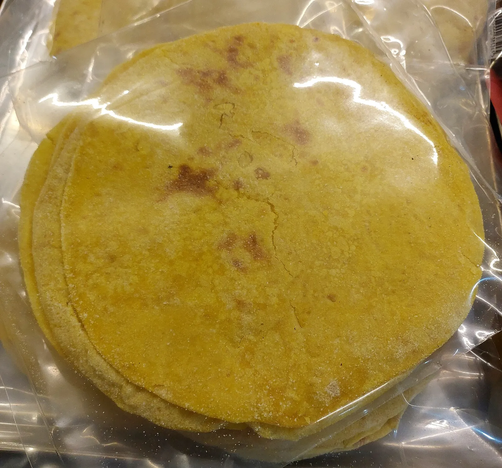 Packeted sweet boli from Kerala, thin yellow boli discs stacked in a plastic pack