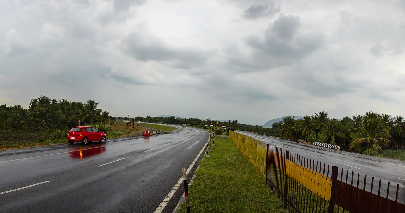 Four-lane NH44 highway in the south, part of the Kashmir to Kanyakumari road, lined with coconut palms