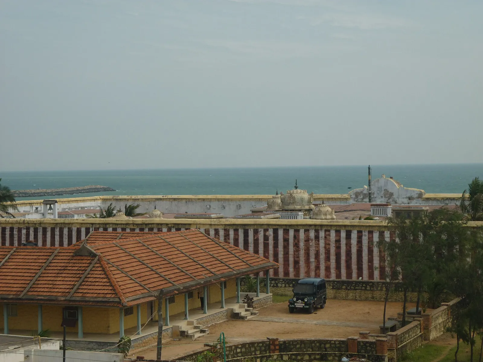 Red-and-white striped walls of the Kumari Amman Bhagavathy Amman temple in Kanyakumari beside the sea, where men remove shirts as part of the temple dress code