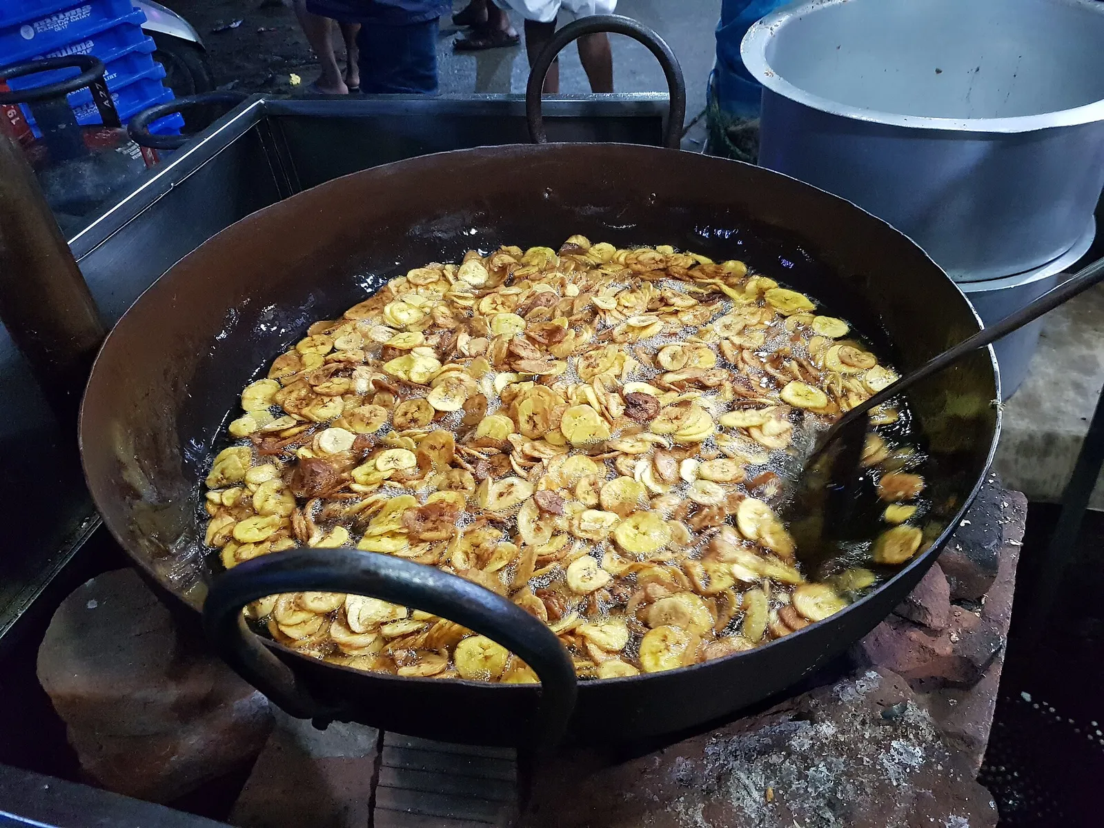 Banana chips frying in a large iron kadai at a shop in Palakkad, Kerala, showing the oil colour to check at a fresh chips shop